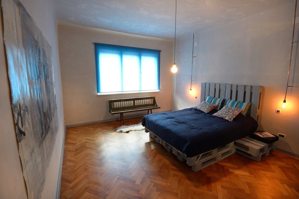 Спальня с деревянной кроватью из поддонов